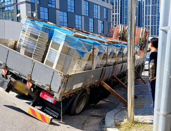 A 25-ton truck lies in the sinkhole that opened up in Incheon on Friday. [INCHEON FIRE SERVICES] 