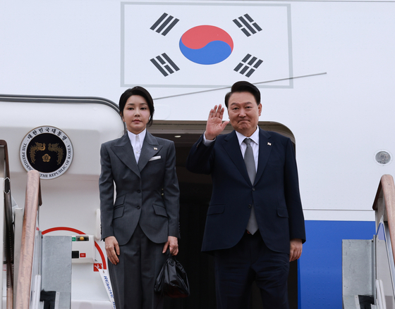 President Yoon Suk Yeol, right, accompanied by first lady Kim Keon Hee, departs from Seoul Air Base in Seongnam, Gyeonggi, Sunday to head for a six-day visit to the Philippines, Singapore and Laos. [JOINT PRESS CORPS]