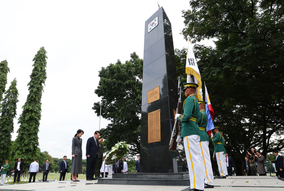 President Yoon Suk Yeol, center, and first lady Kim Keon Hee, left, pay respects at the Korean War Memorial in Manila on Sunday, beginning a state visit to the Philippines, the first leg of a three-nation, six-day trip to Southeast Asia. [JOINT PRESS CORPS]