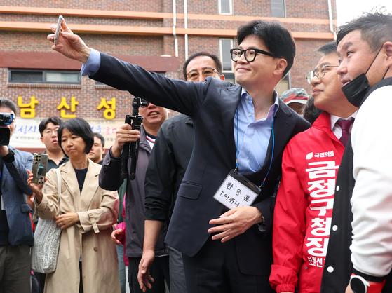 People Power Party leader Han Dong-hoon poses for a photograph with people in Busan's Geumjeong District on Sunday. [YONHAP]