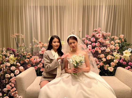 Jiyeon of girl group T-ara, right, and singer IU at Jiyeon's wedding in December 2022 [SCREEN CAPTURE]