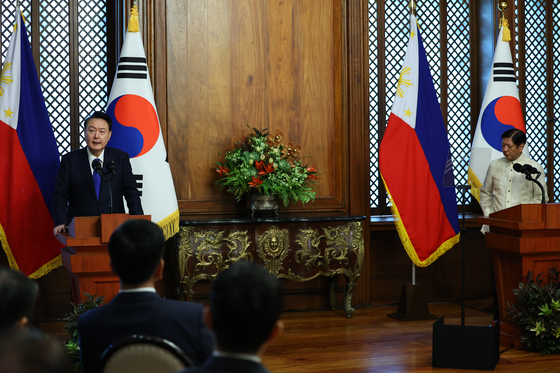 Korean President Yoon Suk Yeol, left, and Philippine President Ferdinand Marcos Jr. issue a joint press statement after their talks at Malacanang Palace in Manila on Monday. [JOINT PRESS CORPS]