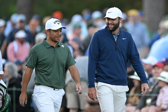 Scottie Scheffler, right, and Xander Schauffele laugh together while walking off the 17th tee box during the second round of the Masters Tournament at Augusta National Golf Club on April 12 in Augusta, Georgia. [GETTY IMAGES]