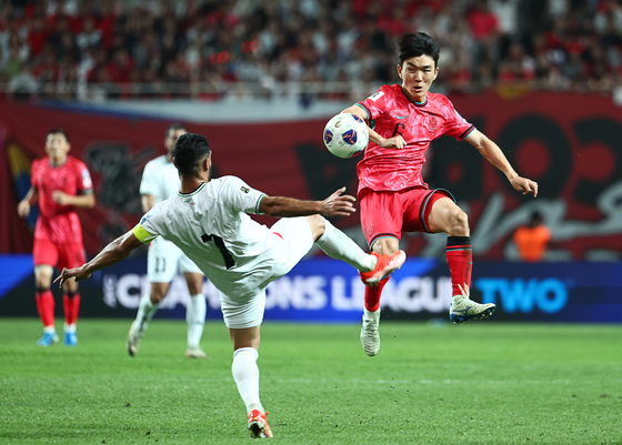 Korea's Hwang In-beom, right, vies for the ball during a 2026 World Cup qualifier against Palestine at Seoul World Cup Stadium in western Seoul on Sept. 5. [YONHAP] 