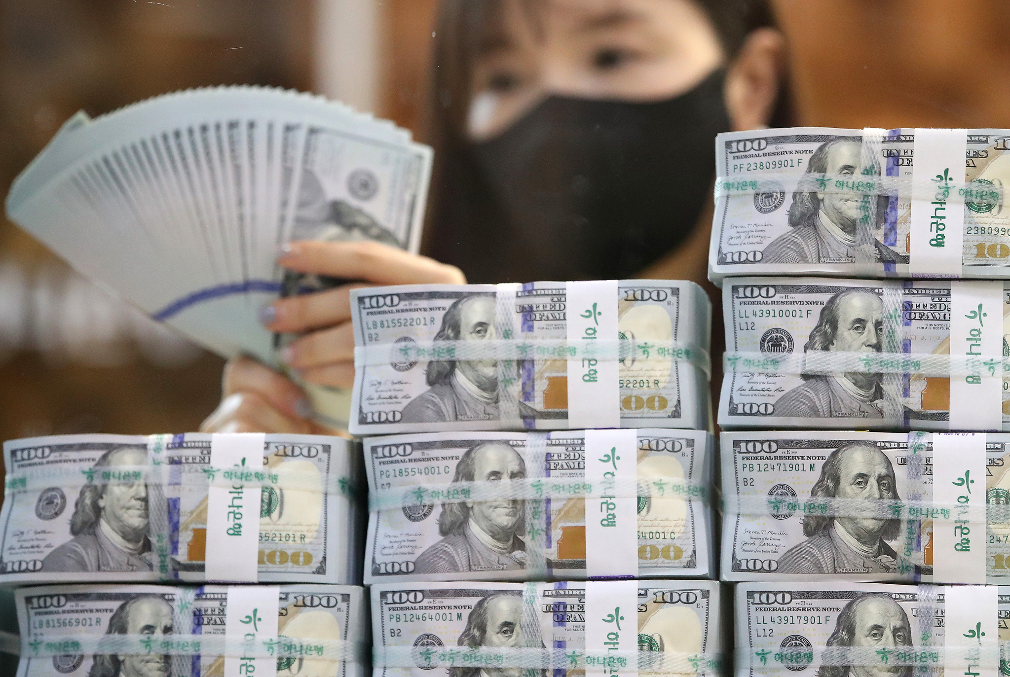 A banker checks dollars at KEB Hana Bank's Counterfeit Notes Response Center in Seoul on July 3. [NEWS1]