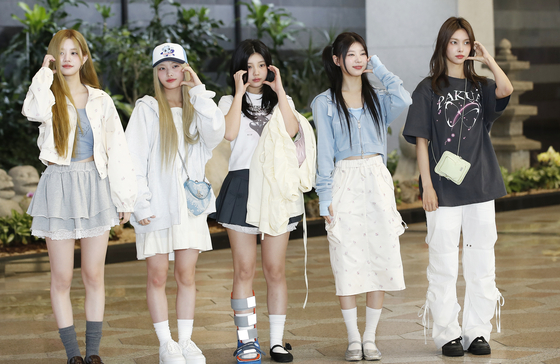 Girl group ILLIT pose for a photo at Gimpo International Airport. [NEWS1]