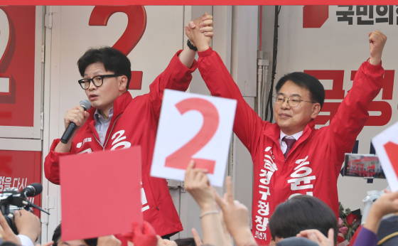 People Power Party (PPP) leader Han Dong-hoon, left, speaks during a Wednesday rally near Pusan National University for Yoon Il-hyun, right, who is the party's candidate for chief of Busan's Geumjeong District. [YONHAP]