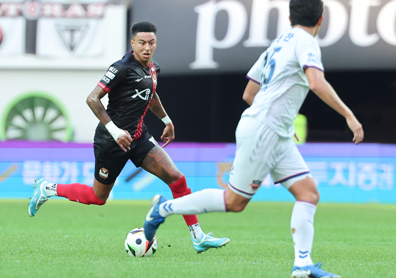 FC Seoul midfielder Jesse Lingard, left, dribbles the ball during the K League 1 match against Suwon FC at Seoul World Cup Stadium in western Seoul on Sept. 29. [NEWS1] 