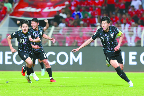 Korea's Son Heung-min, right, celebrates during a 2026 World Cup qualifier against Oman at Sultan Qaboos Sports Complex in Oman on Sept. 10. [YONHAP]