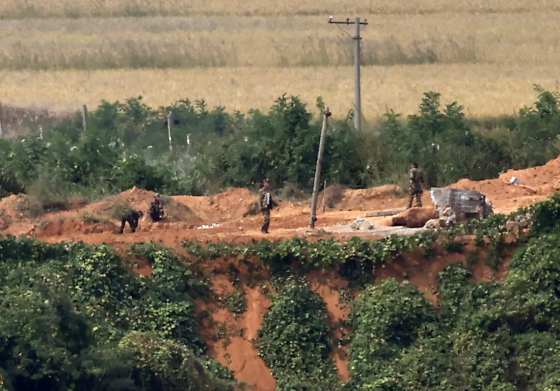 North Korean soldiers are seen working along the inter-Korean border in this photograph from the Odusan Unification Observatory in Paju, Gyeongggi, on Wednesday. [YONHAP]