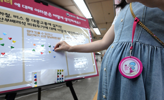 A pregnant woman places a sticker on a survey board during a campaign for expectant mothers in the waiting area of Yeouido Station in western Seoul on July 30. [NEWS1]