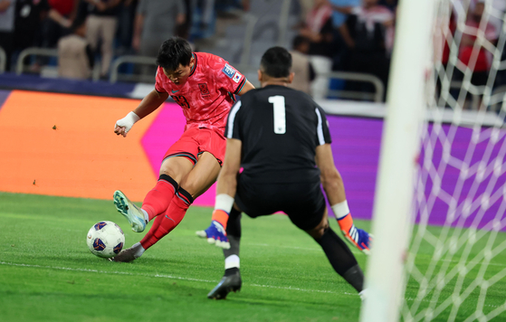 Korea's Oh Hyeon-gyu, left, shoots during a 2026 World Cup qualifier against Jordan at Amman International Stadium in Jordan on Thursday. [NEWS1]