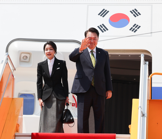 President Yoon Suk Yeol and first lady Kim Keon Hee wave as they board their plane before returning to Korea at Wattay International Airport in Vientiane, Laos, on the Friday, after completing their schedules related to the Asean summit. [YONHAP]