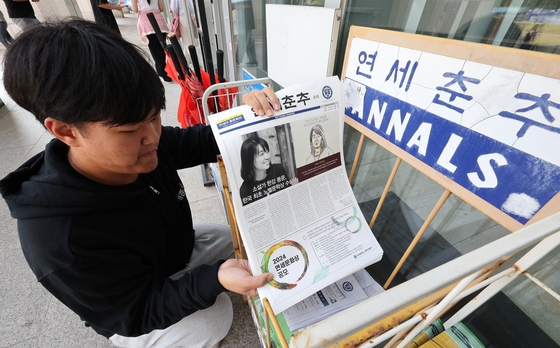 A student places a special edition of the Yonsei Chunchu, celebrating author Han Kang for winning the Nobel Prize in Literature, on a newspaper stand on Friday. [NEWS1] 