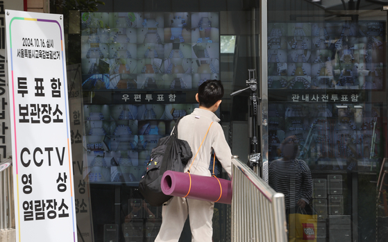 A child watches live footage from surveillance cameras at the Seoul Election Commission office in Jongno District, central Seoul, on Sunday. The office stores ballot boxes from the two-day early voting for the Oct. 16 by-election held on Friday and Saturday to select the city's superintendent of education. [YONHAP]