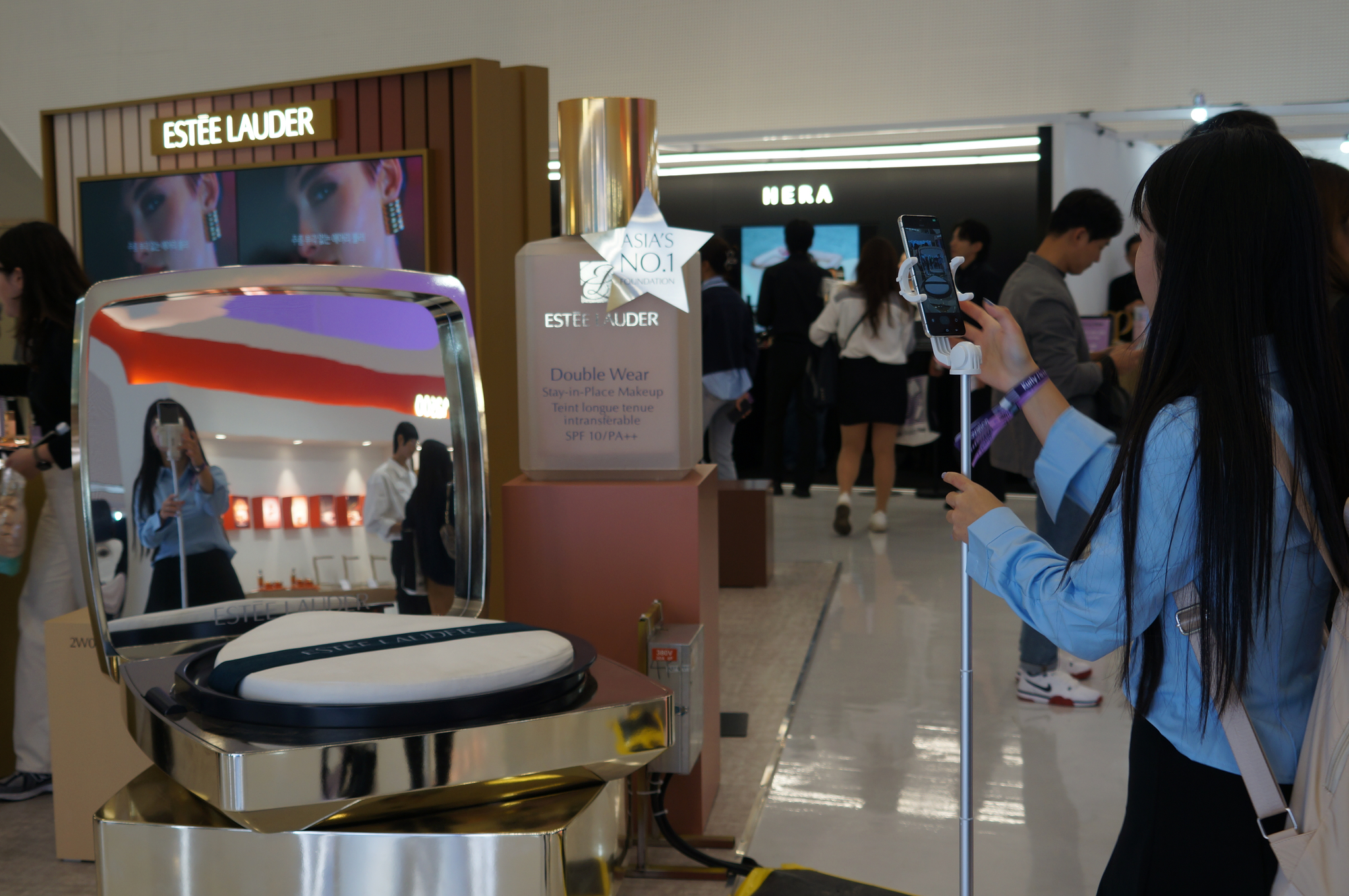 A visitor takes a photo in front of a large cushion foundation display at Estée Lauder's booth in the Beauty Kurly Festa on Oct. 10. [KIM JU-YEON]