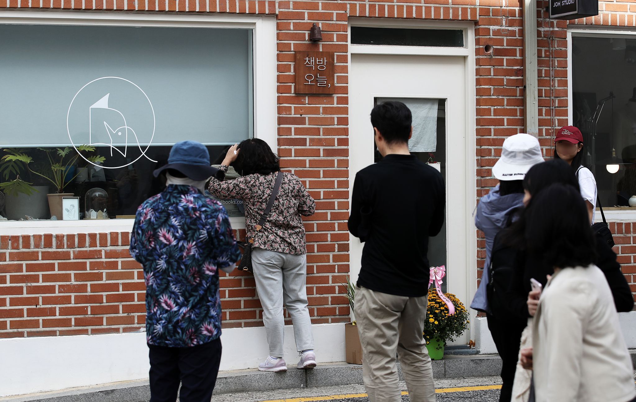 People crowd around Korean novelist Han Kang's independent bookstore in Jongno District's Tongui-dong, central Seoul, on Sunday to congratulate her on winning the Nobel Prize in Literature. The bookstore is temporarily closed. [NEWS1] 