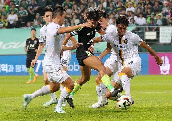 Jeonbuk Hyundai Motors midfielder Lee Seung-woo, center, vies for the ball during a K League 1 match against Gwangju FC at Jeonju World Cup Stadium in Jeonju, North Jeolla, on Aug. 9. [NEWS1]