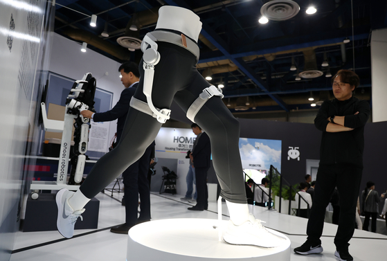 Visitors look at a wearable robot at a booth during the Smart Life Week event at COEX in southern Seoul on Thursday. The inaugural event, which ran from Thursday to Saturday, showcased technologies from 115 cities and institutes and 147 companies. [YONHAP] 