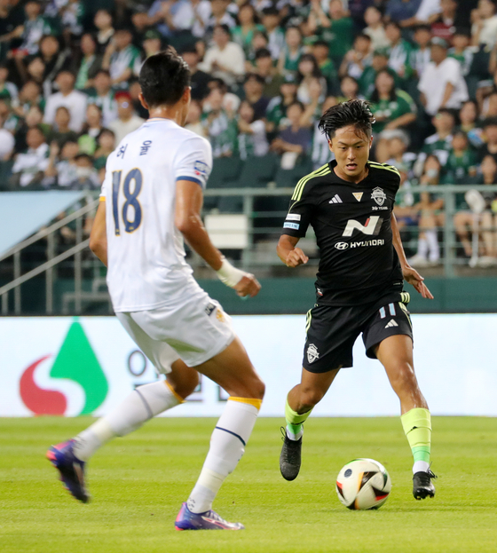 Jeonbuk Hyundai Motors midfielder Lee Seung-woo, right, dribbles the ball during a K League 1 match against Gwangju FC at Jeonju World Cup Stadium in Jeonju, North Jeolla, on Aug. 9. [NEWS1]  