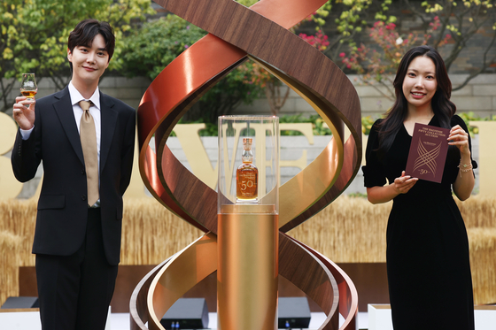 Models introduce a bottle of Scotch whiskey from the Balvenie Fifty Collection at Hotel Shilla in Jung District, central Seoul, on Monday. [YONHAP]