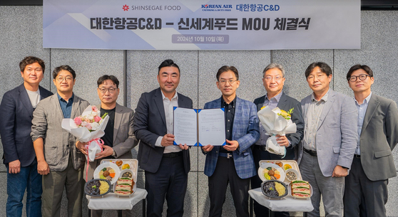 Shinsegae Food CEO Song Hyun-seok, fourth from left, and Korean Air C&D Service CEO Choi Deok-jin, fifth from left, pose for a photo at Shinsegae Food's headquarters in Seongdong District, eastern Seoul, on Oct. 10 after signing a memorandum of understanding regarding plant-based meals. [SHINSEGAE FOOD]