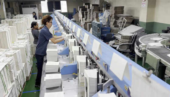 Staff members at Hyprint printing company in Goyang, Gyeonggi, print out Han's books on Sunday. [JOONGANG ILBO]