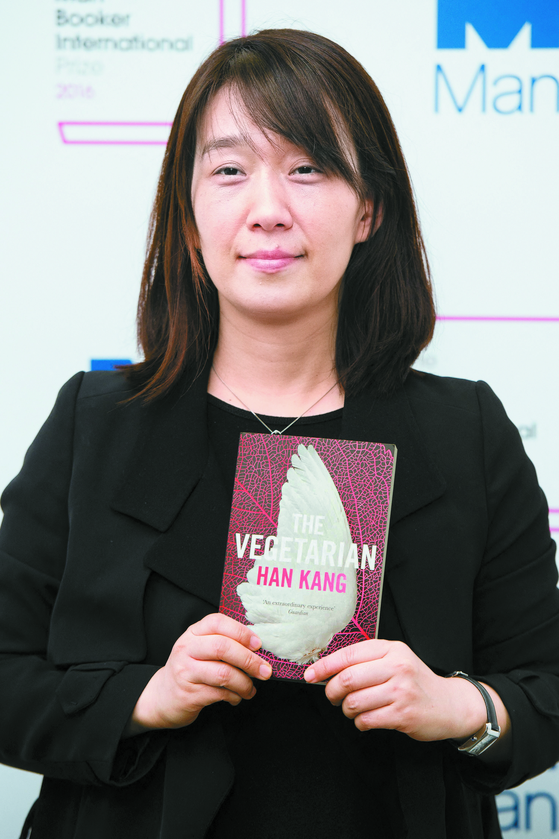 Korean author Han Kang poses for a photograph with her book 