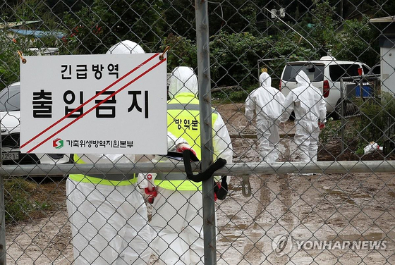 Police officers prevent entry to a pig farm that has been quarantined to prevent the spread of African swine fever to other farms. [YONHAP] 