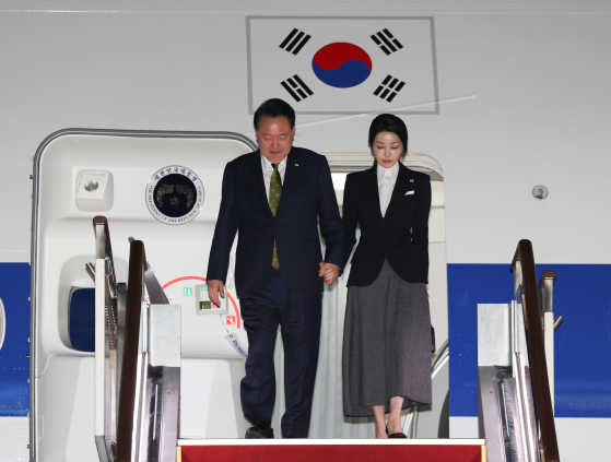 President Yoon Suk Yeol, left, and first lady Kim Keon Hee disembark from the presidential plane at Seoul Air Base in Seongnam, Gyeonggi, after completing an official trip to Southeast Asia on Friday. [YONHAP]