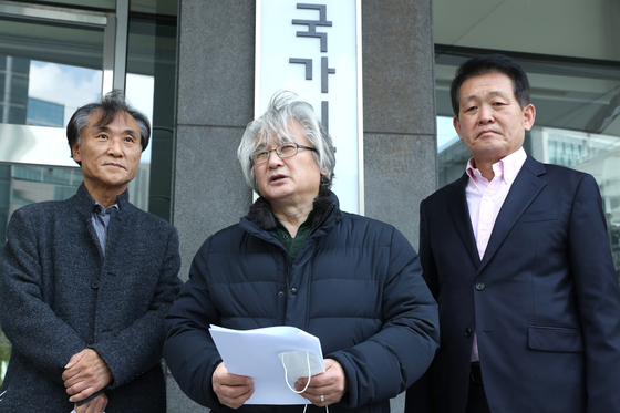 Kim Min-woong, center, speaks to reporters before submitting a petition to the National Human Rights Commission on April 27, 2020, calling for an investigation into human rights violations during the prosecution's investigation of former Justice Minister Cho Kuk. [YONHAP] 