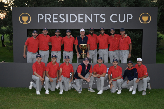 U.S. Team players pose for a photo with the Presidents Cup Trophy after winning the 2024 Presidents Cup at The Royal Montreal Golf Club on Sept. 29 in Montreal, Quebec. [GETTY IMAGES