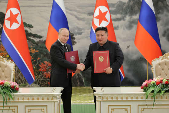 North Korean leader Kim Jong-un, right, shakes hands with Russian President Vladimir Putin in Pyongyang after signing a comprehensive strategic partnership treaty in June. [RODONG SINMUN]