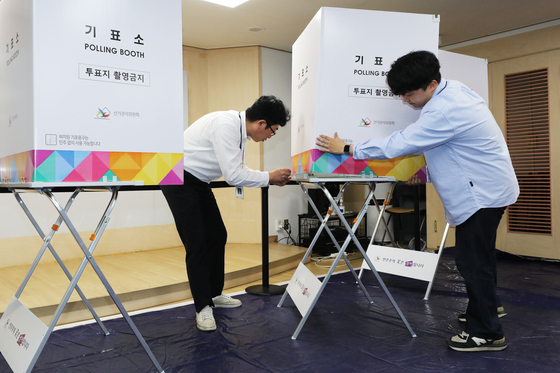 Officials from the National Election Commission set up a polling station in Songpa District, southern Seoul, on Tuesday, a day before the by-election for Seoul's superintendent of education. [JOINT PRESS CORPS] 