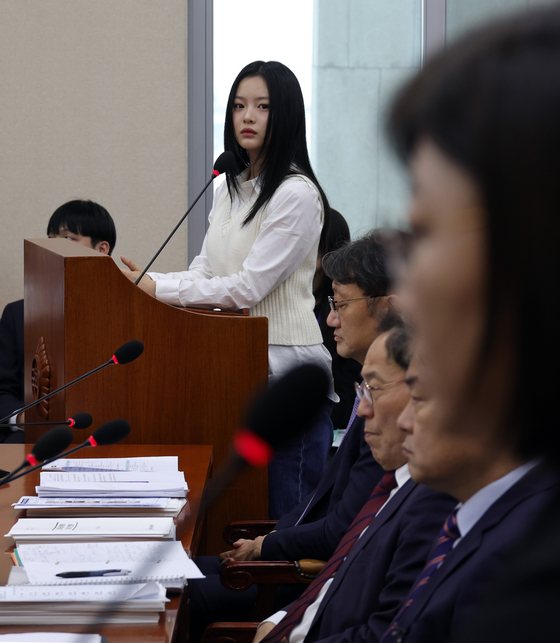 Hanni of girl group NewJeans looks at her agency ADOR CEO Kim Ju-young at the National Assembly in western Seoul on Oct. 15. [JOINT PRESS CORPS]