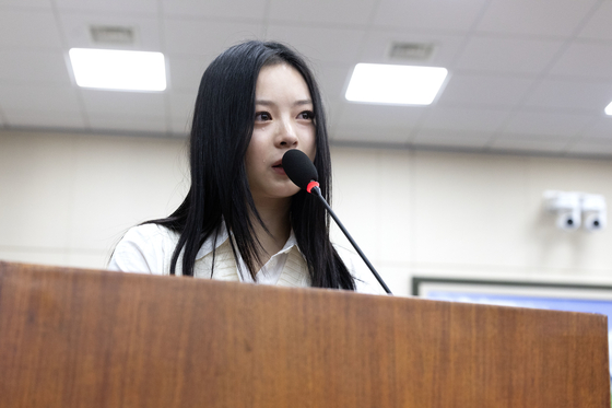 Hanni of girl group NewJeans sheds tears while testifying at the National Assembly's Environment and Labor Committee on Oct. 15 in western Seoul. [JOINT PRESS CORPS]