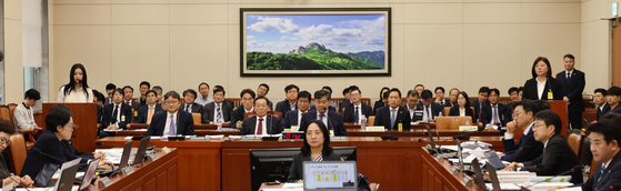 Hanni of girl group NewJeans, far left, and CEO of her agency ADOR, Kim Ju-young at far right, testify at the National Assembly's Environment and Labor Committee on Oct. 15 in western Seoul. [JOINT PRESS CORPS]