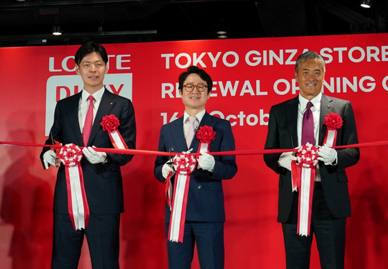 From left, Shin Yoo-yeol, executive director of the Future Growth Office at Lotte Corporation; Lotte Duty Free CEO Kim Ju-nam; and Lotte Holdings CEO Genichi Tamatsuka hold a ribbon-cutting at the renewal opening ceremony for Lotte Duty Free's store in Tokyo's Ginza district on Wednesday morning. [LOTTE DUTY FREE]