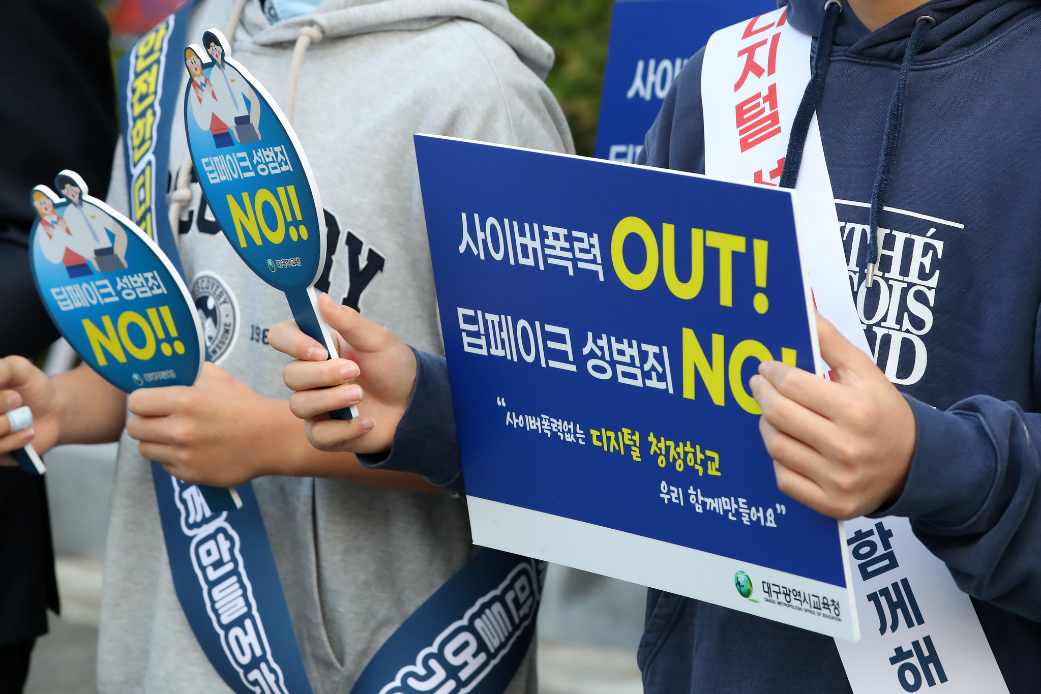 Students and their parents participate in a campaign to raise awareness of deepfake sex crimes while holding pickets in front of Dongdo Middle School in Daegu on Oct. 8. [NEWS1]