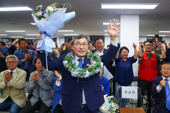 Liberal candidate Jung Geun-sik celebrates as he nears victory in the by-election for Seoul's superintendent of education at his office in Mapo District, western Seoul, on Wednesday. [YONHAP] 