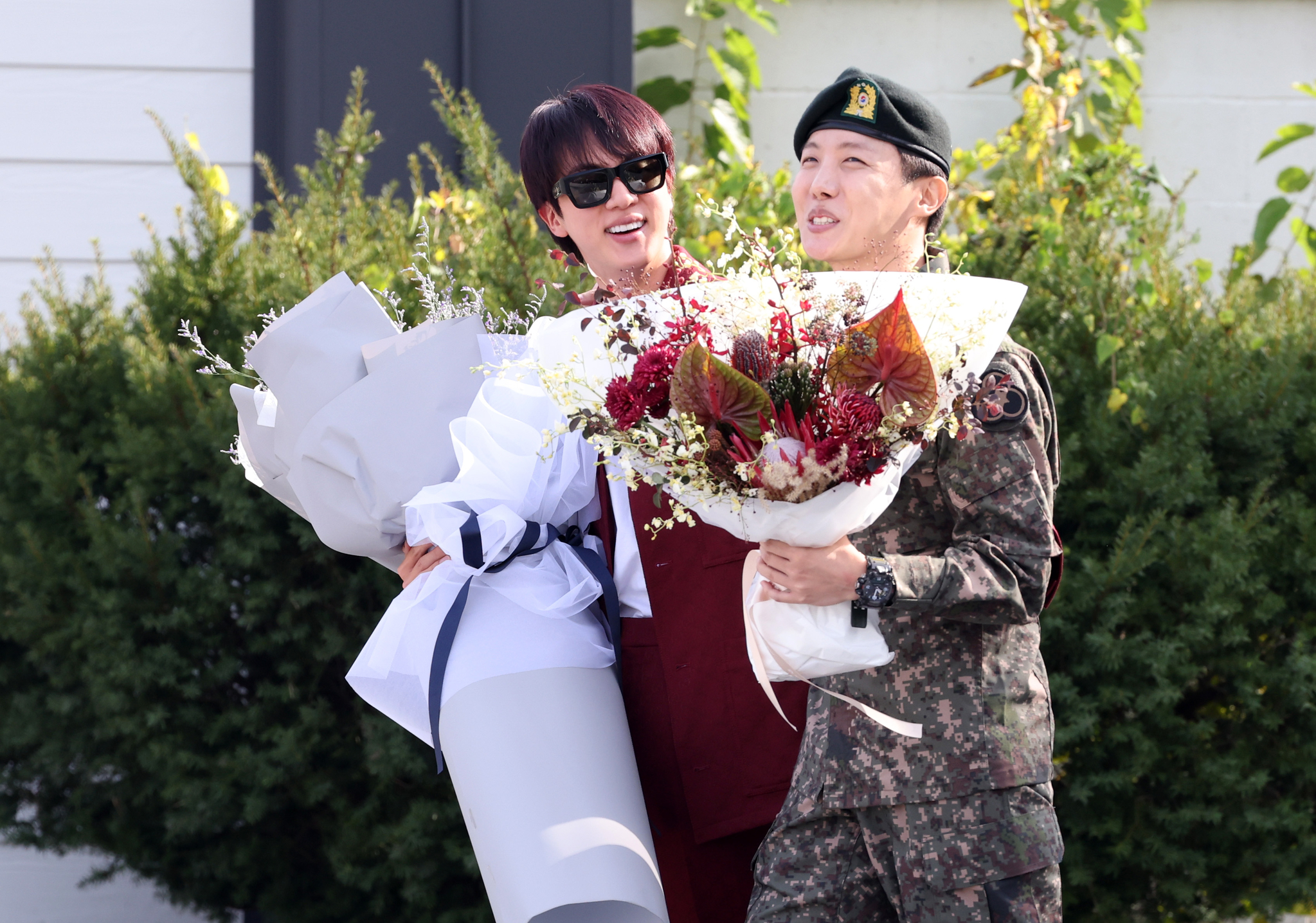 BTS member Jin, left, greets his bandmate J-Hope as the latter finishes his military duty on Oct. 17 in Wonju, Gangwon. [YONHAP]