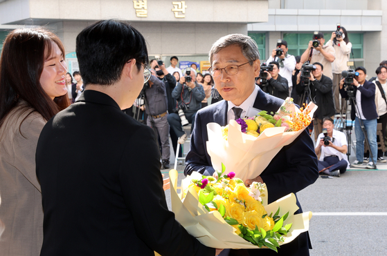 Jung Geun-sik, right, receives flowers from officials at the Seoul Metropolitan Office of Education as he arrives for his first day as the city's new education superintendent on Thursday. [JOINT PRESS CORPS]