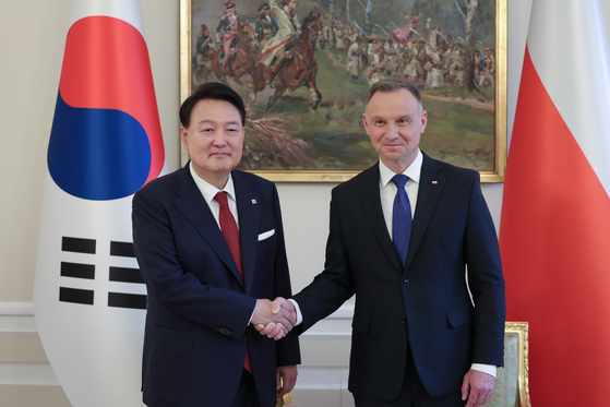 Korean President Yoon Suk Yeol, left, and Polish President Andrzej Duda shake hands during their summit talks at the presidential palace in Warsaw on July 13, 2023. [PRESIDENTIAL OFFICE] 