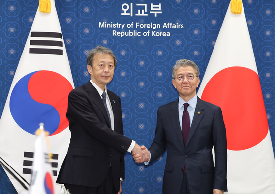 Korean Vice Foreign Minister Kim Hong-kyun, right, and Japanese Vice Foreign Minister Masataka Okano shake hands at the Korea-Japan vice-ministerial meeting in central Seoul on Thursday. During the meeting held in the morning, the Korean government's message on Japan’s sending of offerings to and paying respects at Yasukuni Shrine was delivered at the level of a spokesperson's commentary, a Foreign Ministry official said. [NEWS1]