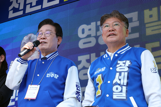 Democratic Party leader Lee Jae-myung, left, speaks during a rally on Oct. 10 for Chang Sae-il, who won the race for Yeonggwang County in South Jeolla. [YONHAP] 