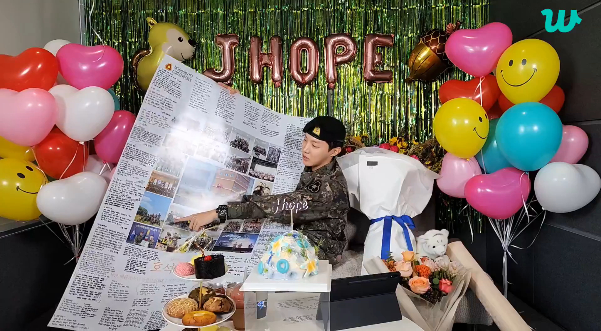 J-Hope shows a large poster filled with letters. [SCREEN CAPTURE]