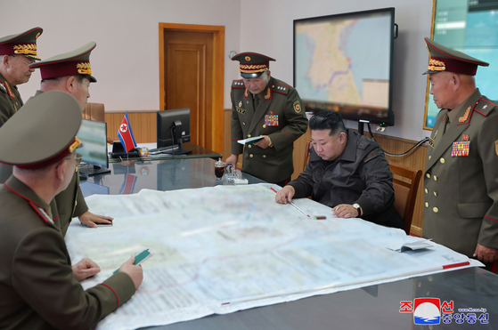 North Korean leader Kim Jong-un, center, points to a spot on a large map during his inspection of the 2nd Corps of the Korean People's Army on Thursday in a photo released by the regime's state-run Korean Central News Agency (KCNA) the following day. [KOREAN CENTRAL NEWS AGENCY]