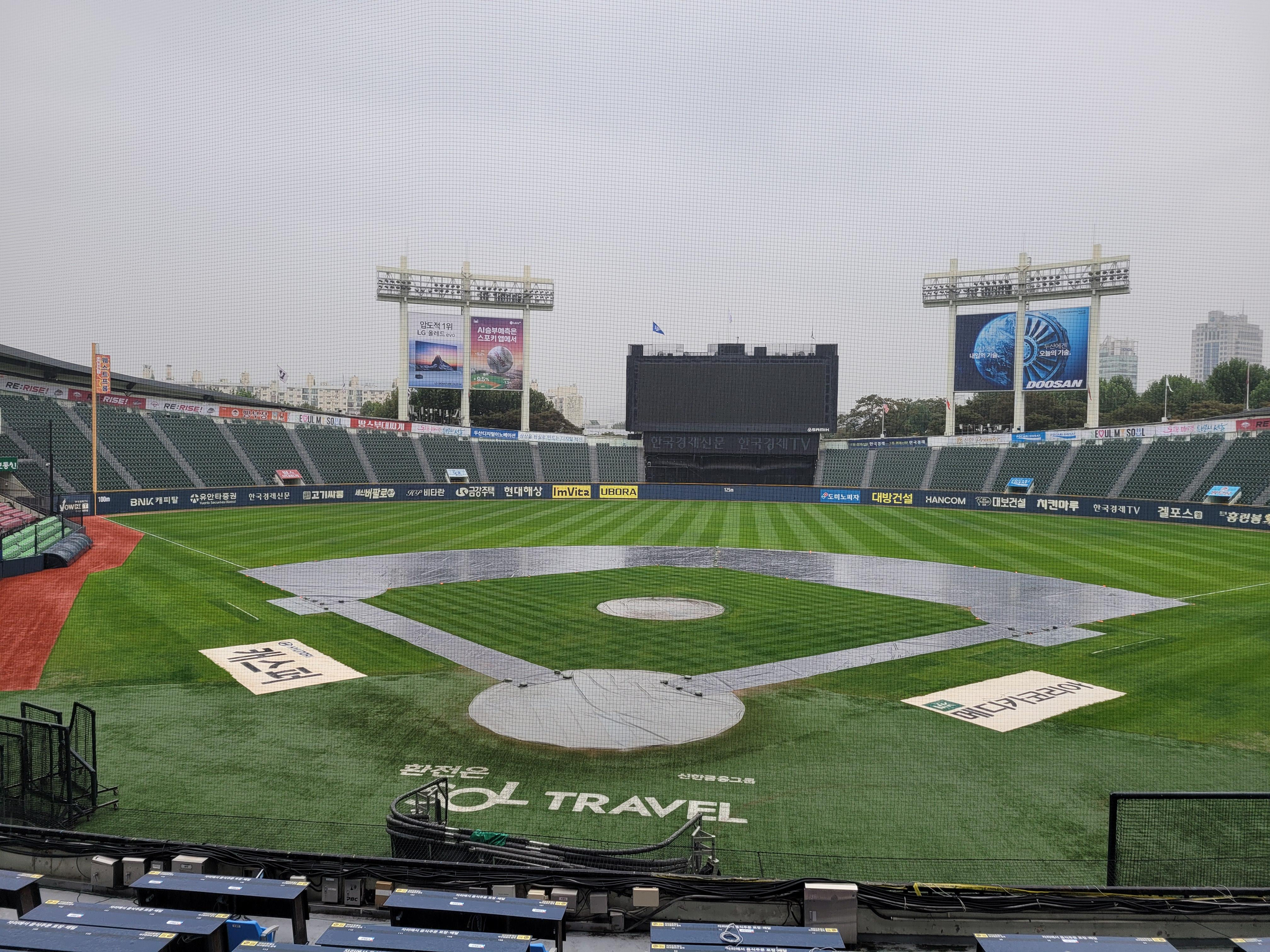 The infield dirt at Jamsil Baseball Stadium in Seoul is covered with tarp on Friday, before a Korea Baseball Organization postseason game between the Samsung Lions and the LG Twins was rained out. [YONHAP]