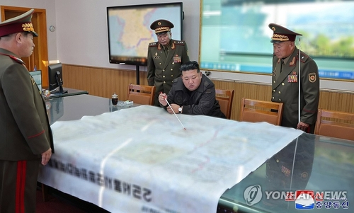 North Korean leader Kim Jong-un, center, points to a spot on a large map during his inspection of the 2nd Corps of the Korean People's Army on Thursday. [KOREAN CENTRAL NEWS AGENCY]