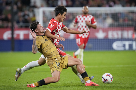 Girona midfielder Kim Min-su, right, vies for the ball during a La Liga match against Real Sociedad at Estadi Montilivi in Spain on Saturday. [EPA/YONHAP]